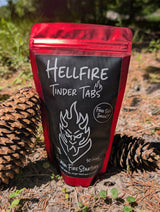 Hellfire Tinder Tabs packaging with two pine cones on a forest floor background