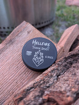 black tin of Hellfire Tinder Discs sitting on split firewood
